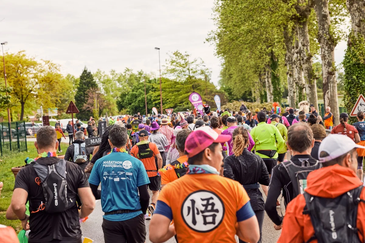 Peloton du Marathon Bresse Dombes, avec un coureur de dos portant une tenue orange Dragon Ball.